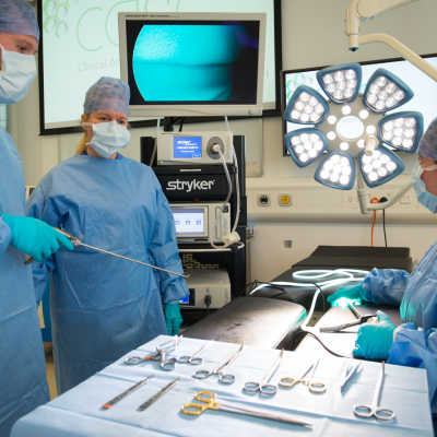 Three people in surgical dress at a casc course 