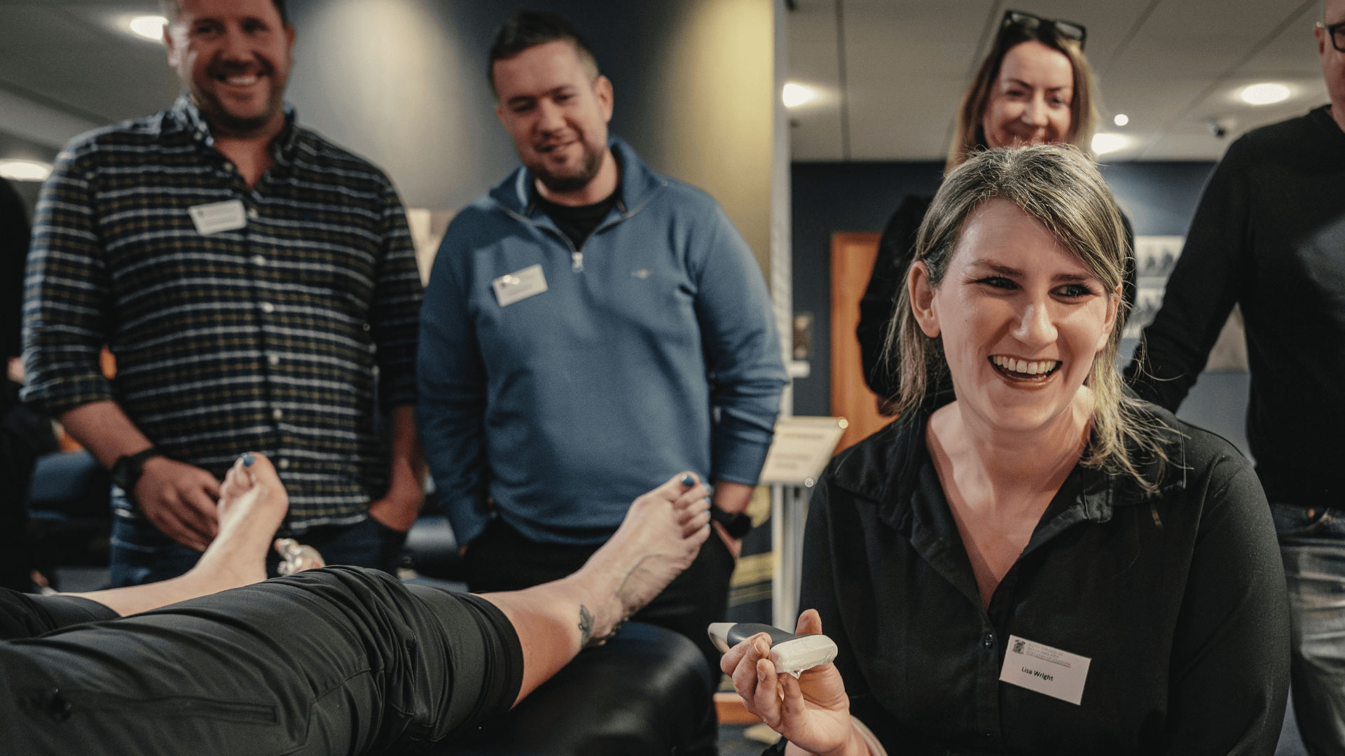 a group smiling whilst carrying out a podiatric ultrasound