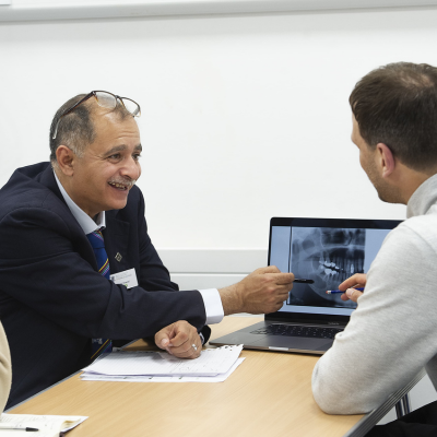 two people looking at a laptop with one describing to the other