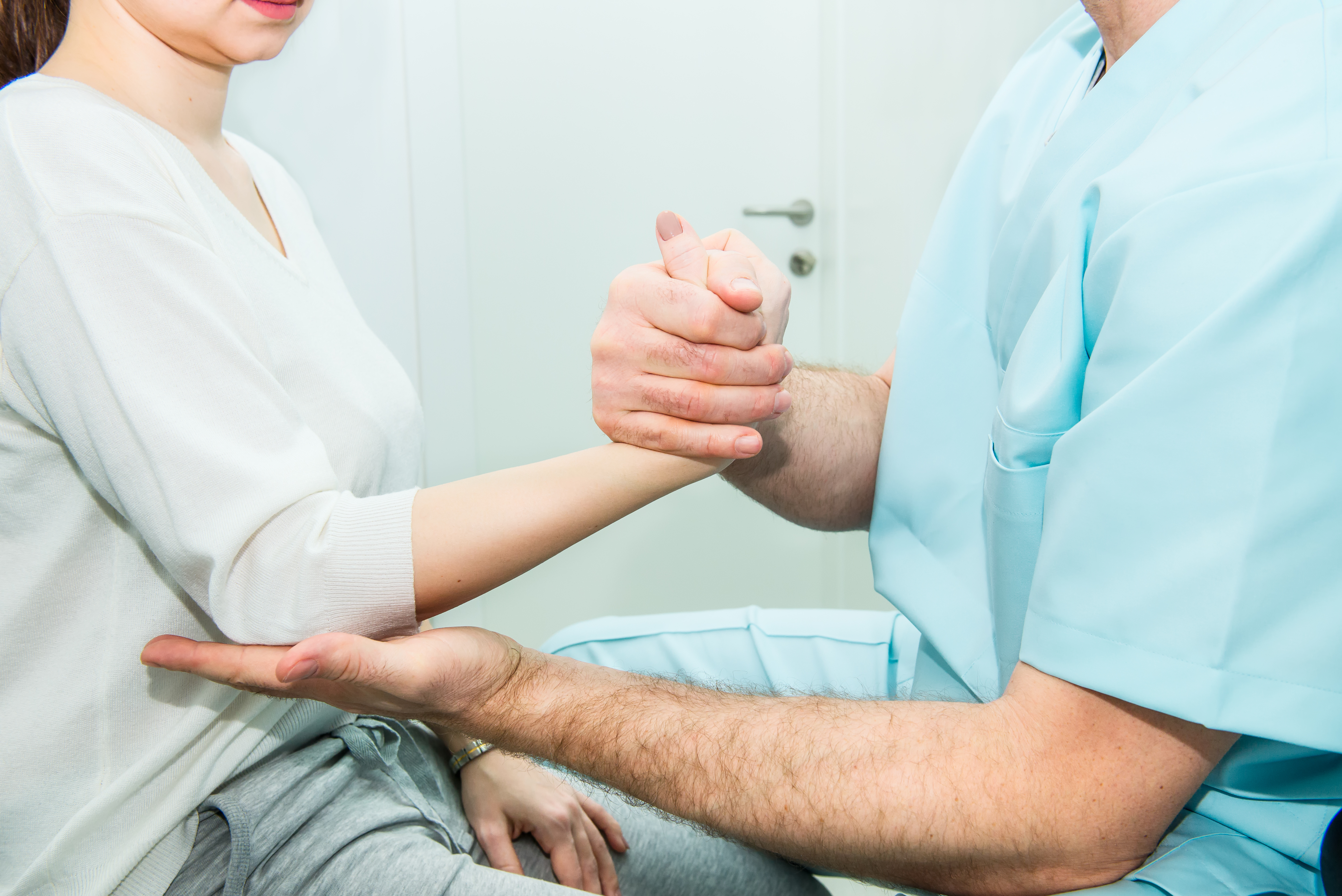 A medical professional assessing an arm