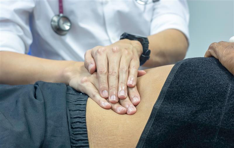 Dr with both hands on patients abdomen