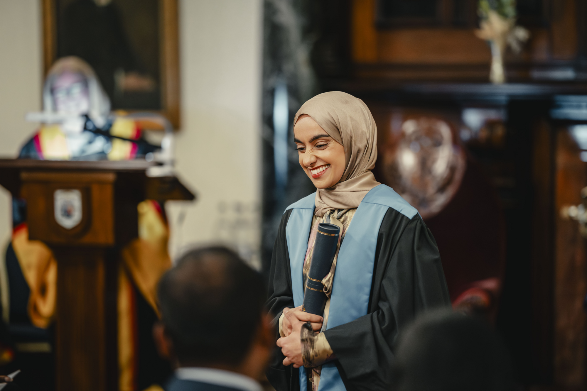 A woman smiling with her diploma