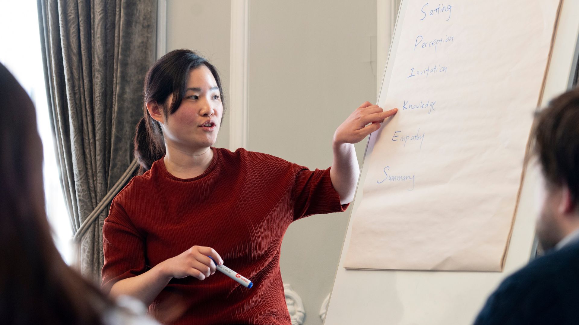 A woman standing in front of a flipchart